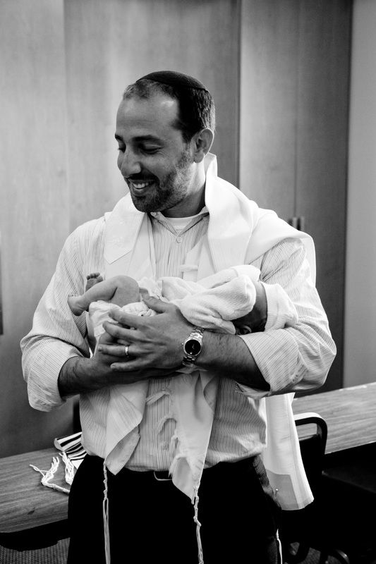 A father holding his newborn son close, in black and white